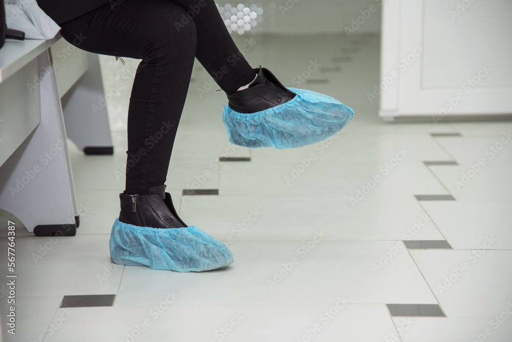Abstract image with feet in boot covers in a hospital.
