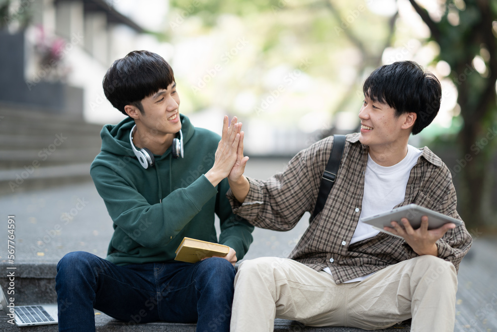 Happy young male college student celebrate together after the project was done successfully.