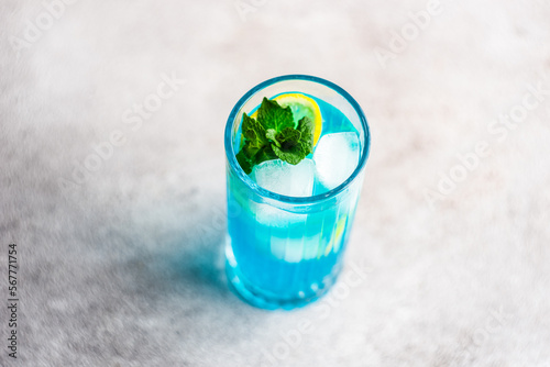 Close-Up of a  blue cocktail with fresh mint and lemon on a table