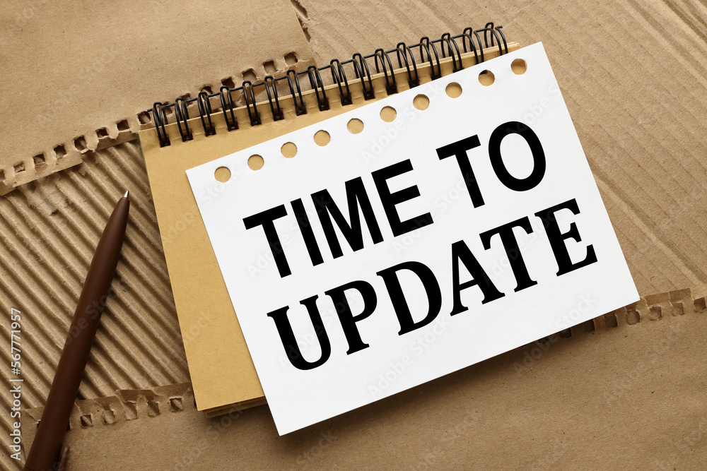Time To Update. text on notebook pages on brown background Time To Update. text on notebook pages on brown background