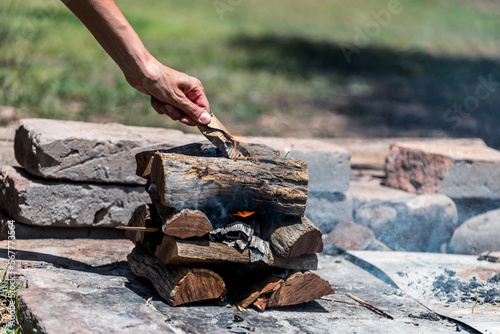 hand lighting fire, logs on fire, typical argentinean food, grilled meat, grilled meat