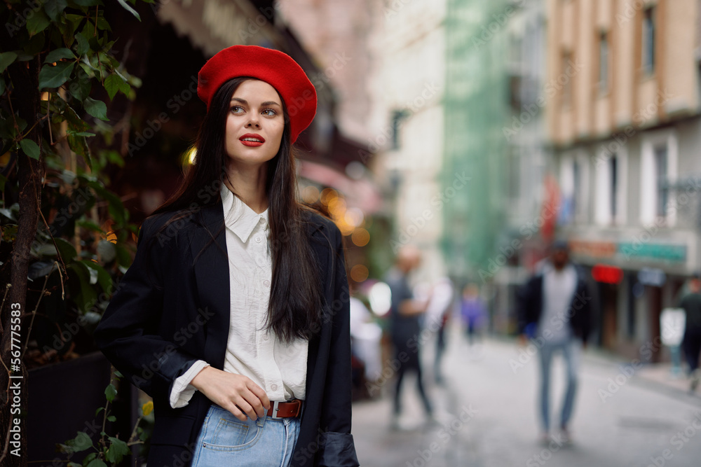 Woman smile fashion model walks on the street in the city center among the crowd in a jacket and red beret and jeans, cinematic french fashion style clothing, travel to istanbul Woman smile fashion model walks on the street in the city center among the crowd in a jacket and red beret and jeans, cinematic french fashion style clothing, travel to istanbul