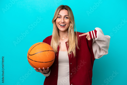 Young caucasian basketball player woman isolated on blue background with surprise facial expression © luismolinero