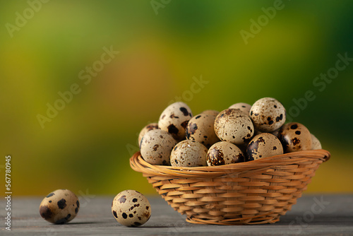 Quail eggs in a small wicker basket on a natural background