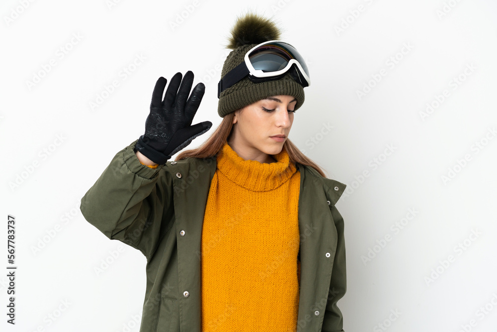 Skier caucasian woman with snowboarding glasses isolated on white background making stop gesture and disappointed