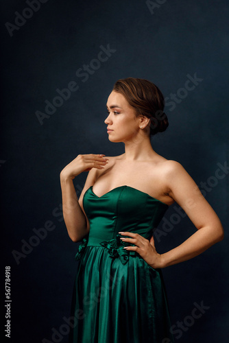A girl in a green dress on a dark blue background