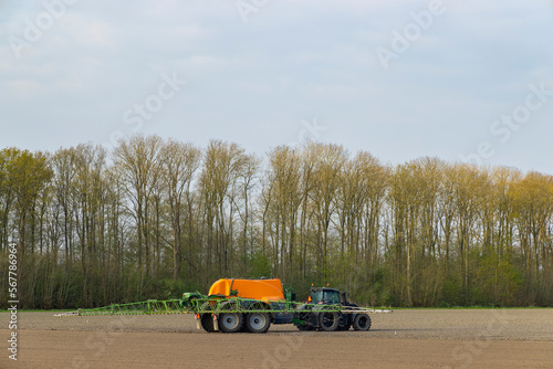 Wallpaper Mural Tractor with a sprayer during spring work in the field Torontodigital.ca