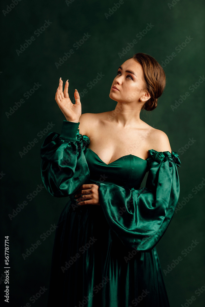waist portrait of a girl in a green dress standing against a green wall waist portrait of a girl in a green dress standing against a green wall