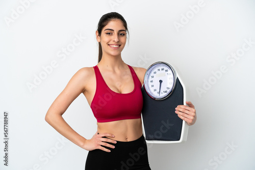 Young caucasian woman isolated on white background with weighing machine