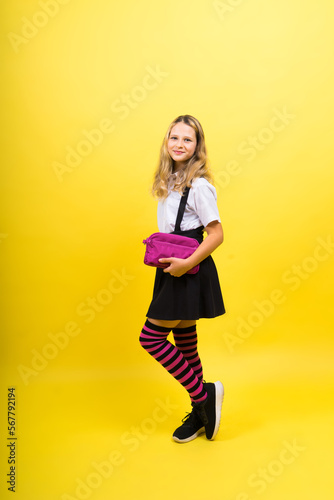 Happy schoolgirl with colored pencils and a pencil case in hand