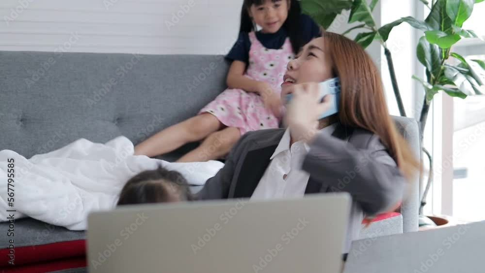 Single mother working at home Tired, busy with work and having to take care of two daughters who are playing mischievously. Family concept. working woman head of family