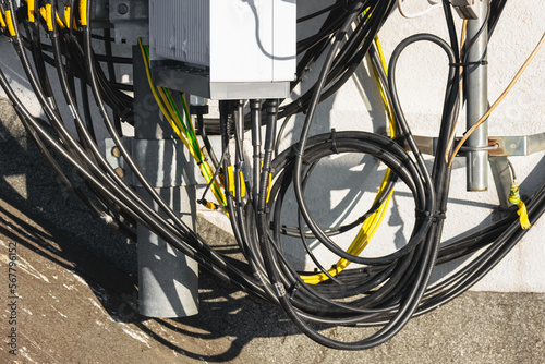 Close-up of a cellular antenna with many power cables, coaxial cables, optical fiber. photo