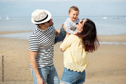 new parents having fun with baby on the beach
