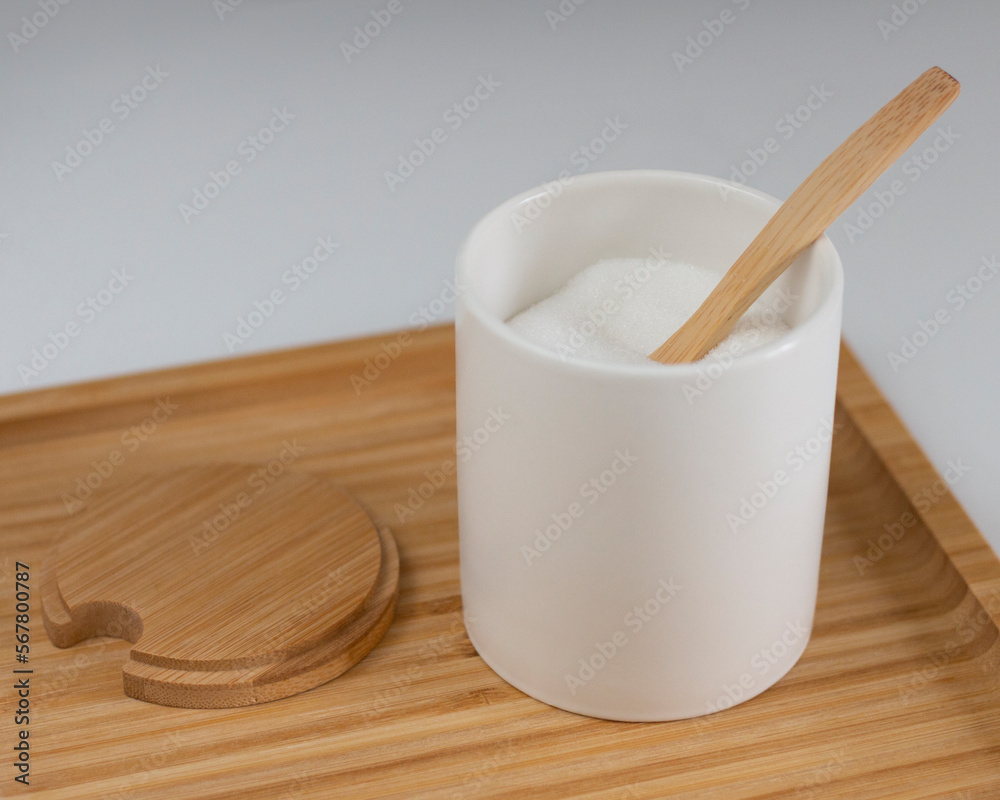 Kitchen jar with white sugar. Wooden spoon and stand. Sweet ingredient for dessert. Closeup photo Kitchen jar with white sugar. Wooden spoon and stand. Sweet ingredient for dessert. Closeup photo