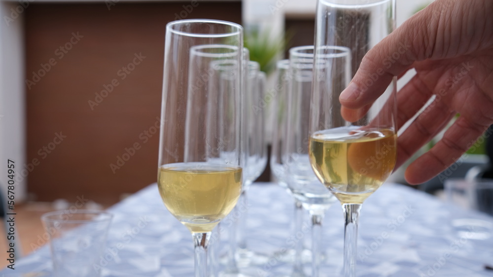 varias copas llenas de champan y mano de una persona cogiendo una de ellas, perfecto para una celebracion o fiesta