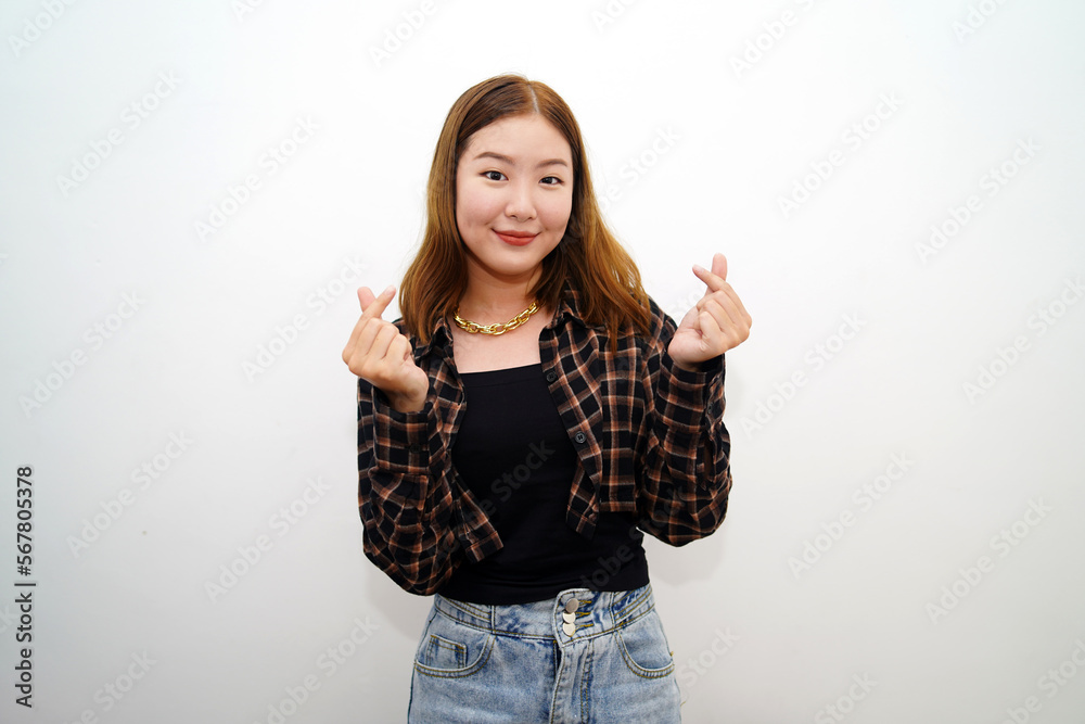A beautiful young asian woman feels happy and showing heart hand sign against white background. People affection and care concept. A beautiful young asian woman feels happy and showing heart hand sign against white background. People affection and care concept.