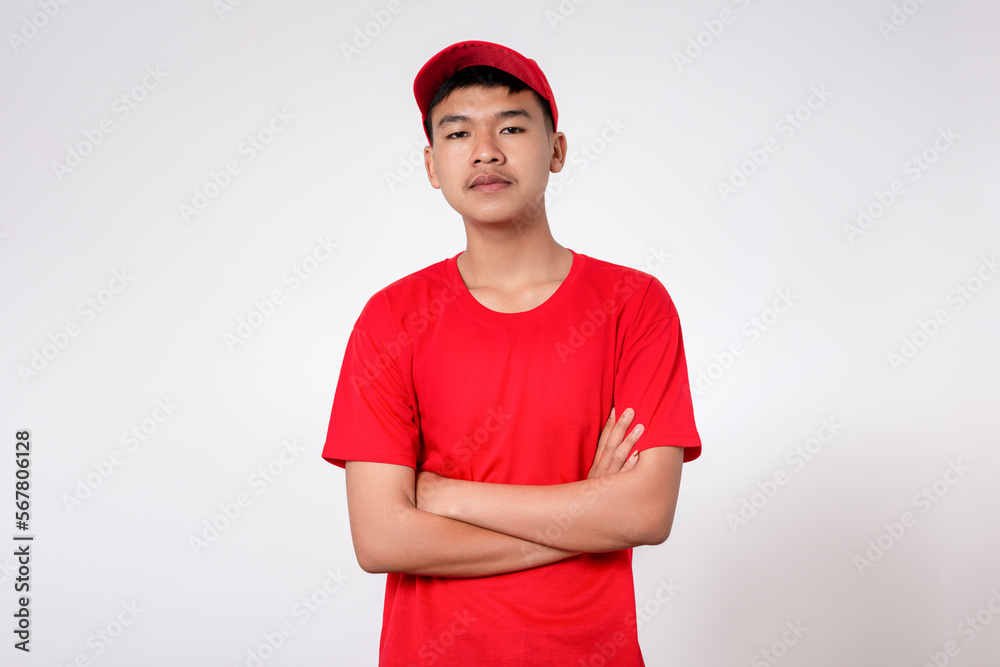 Fototapeta premium Courier Delivery worker shipping concept. Portrait of Smiling young asian Delivery man in red uniform isolated on white background