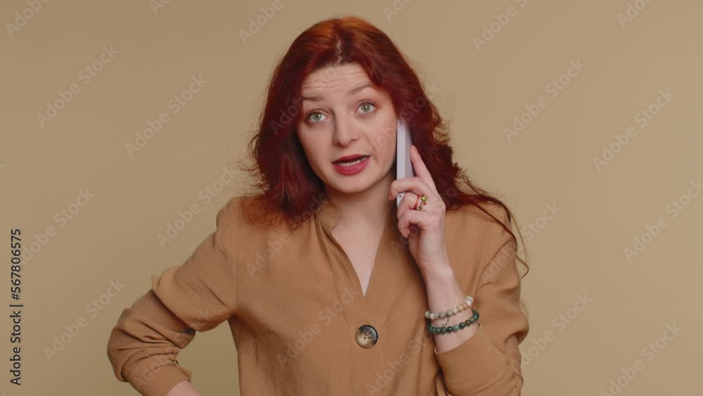 Redhead woman tired sleepy freelancer talking on mobile phone with friend, making online conversation. Disinterested sad young girl having annoyed boring talk on smartphone on beige studio background Redhead woman tired sleepy freelancer talking on mobile phone with friend, making online conversation. Disinterested sad young girl having annoyed boring talk on smartphone on beige studio background