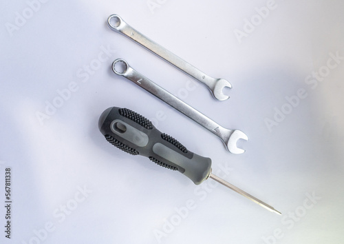 answering machine with rubber gray manual and two open-end wrenches lie on a white background
