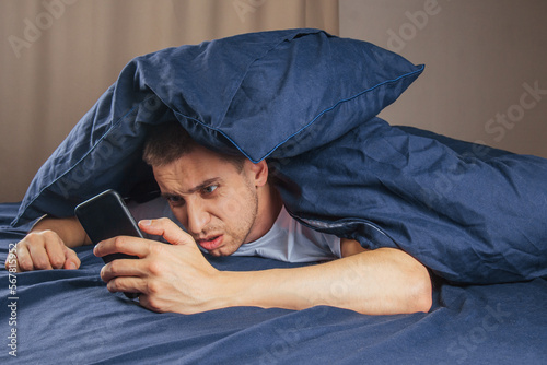 Fotografia Frustrated guy looks at the phone and reads bad news