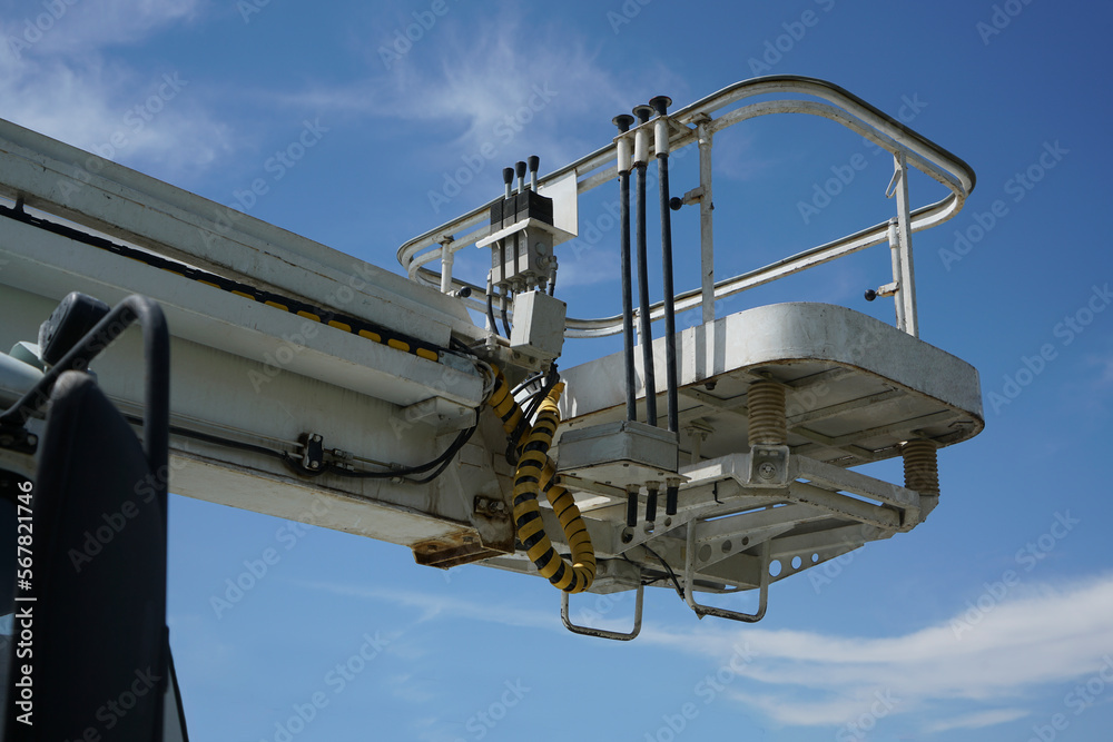 crane truck at the construction site works the installation of the boom of a tower crane, against blue sky background. aerial platform. crane truck at the construction site works the installation of the boom of a tower crane, against blue sky background. aerial platform.