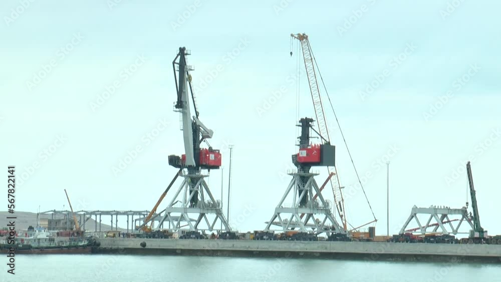 Close-up of two heavy lifting cranes in a seaport Close-up of two heavy lifting cranes in a seaport