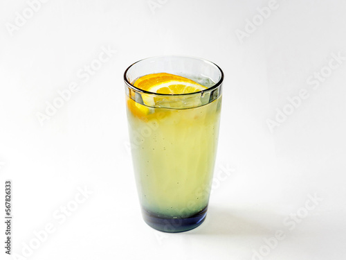 Refreshing lemonade from lemons in glass of colored glass on white background
