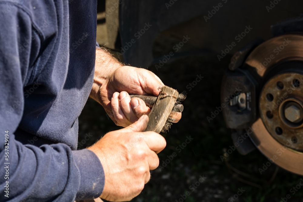 Mechanic cleaning and fixing the brake system of a car in Romania, Targoviste, 2021