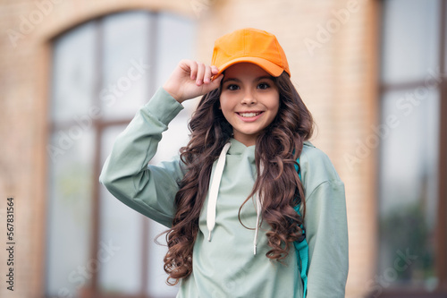 casual teen girl childhood at the street. photo of casual teen girl childhood in cap. photo