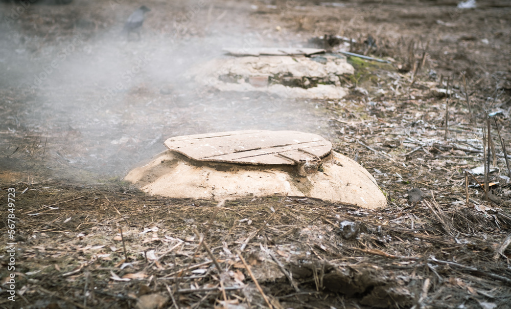 Obraz premium Manholes with fumes on city street in cold weather.