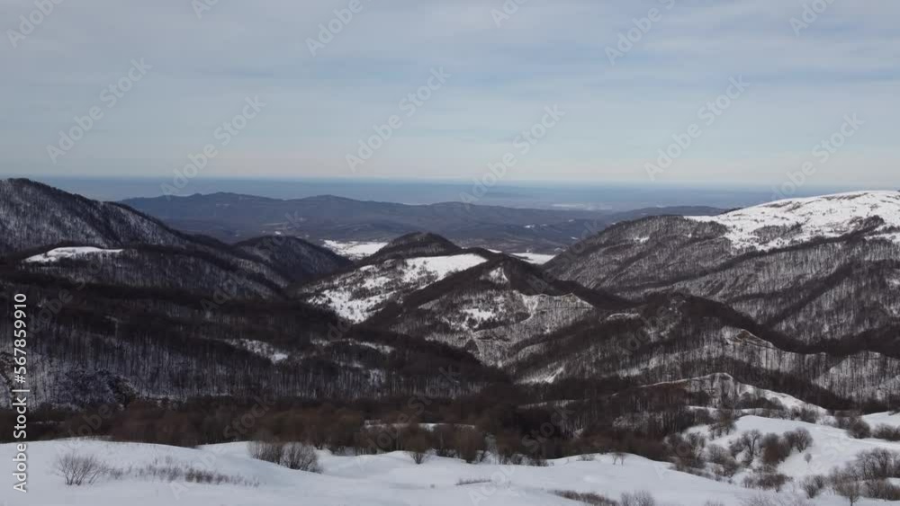 A man on a snowmobile roams the mountains 2023 filming from a drone A man on a snowmobile roams the mountains 2023 filming from a drone