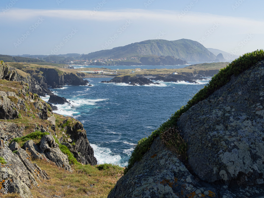 Paisaje natural de costa en Cedeira , Galicia con acantilados, el mar azul con olas blancas chocando contra los acantilados verdes en verano de 2021.