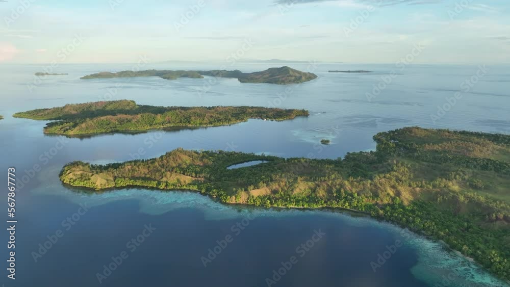 Early morning light shines on tropical islands and coral reefs in the ...