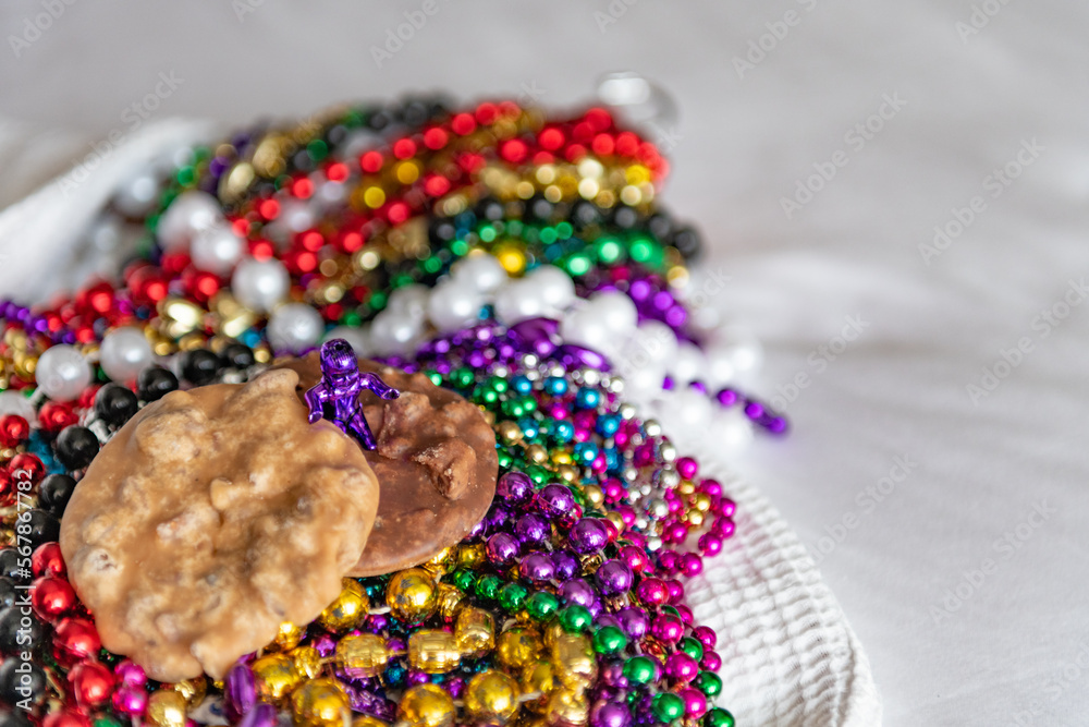 Pralines on top of colorful Mardi Gras beads background with a shallow depth of field