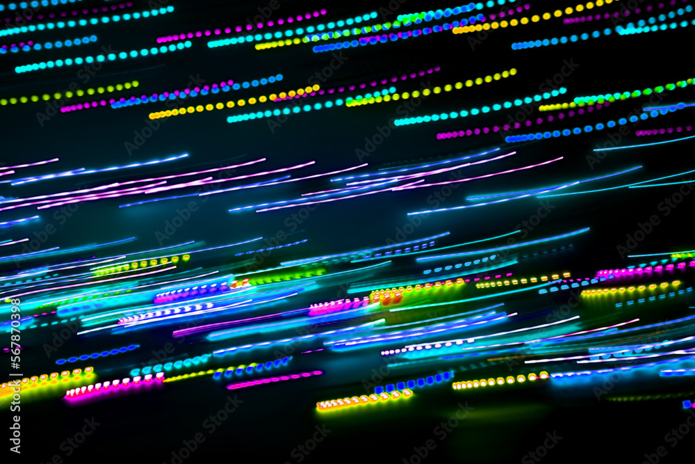 Blurred abstract background. Drawing with light, garlands with multi-colored LED bulbs, shooting while moving at a slow shutter speed. Blurred abstract background. Drawing with light, garlands with multi-colored LED bulbs, shooting while moving at a slow shutter speed.
