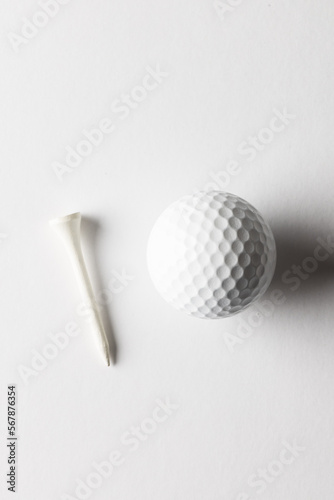 High angle view of white golf ball and golf tee with copy space on white background