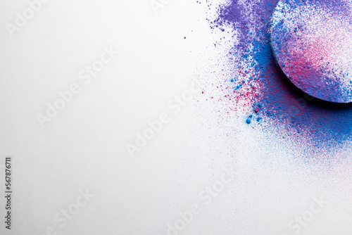 Close up of multi coloured powder with white circle and copy space on white background