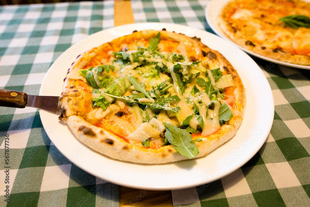 Fresh homemade authentic italian stone oven caesar pizza with arugula, sauce, grilled chicken, herbs and spicy parmesan cheese and margherita. High quality photo. Fresh homemade authentic italian stone oven caesar pizza with arugula, sauce, grilled chicken, herbs and spicy parmesan cheese and margherita. High quality photo.