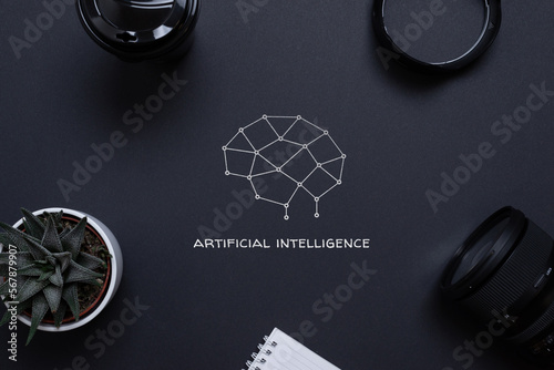 Drawing of a brain from network nodes and artificial intelligence text on a desk, surrounded by office supplies, top view, flat lay. Concept of applying AI in business photo