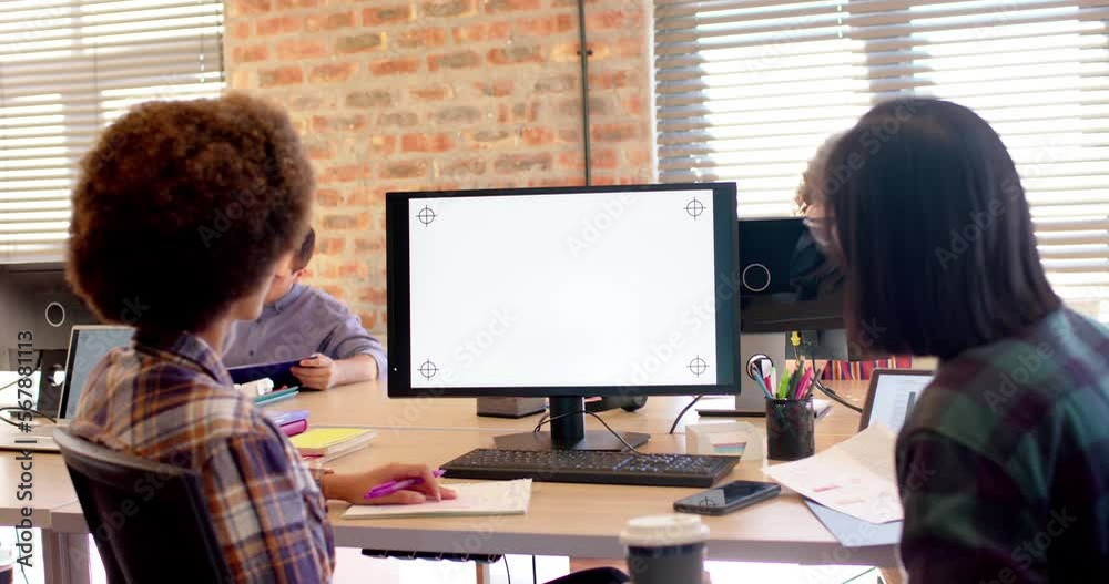 Two happy diverse businesswomen using computer in casual office, copy space on screen, slow motion Two happy diverse businesswomen using computer in casual office, copy space on screen, slow motion