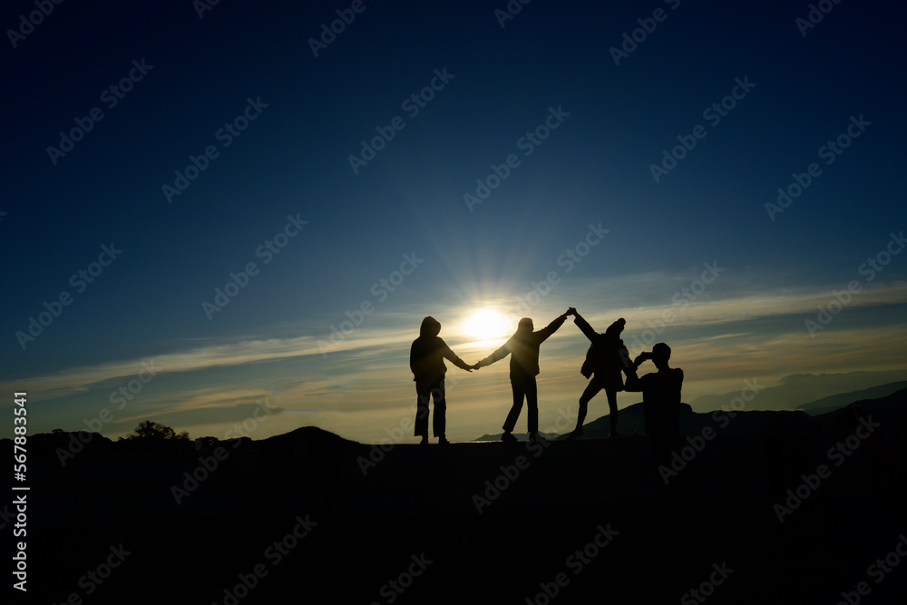A group of young people watching the sun rise from the top of Mount Inthanon