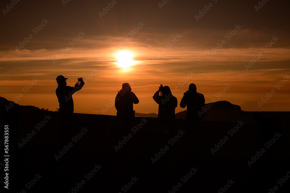 A group of young people watching the sun rise from the top of Mount Inthanon