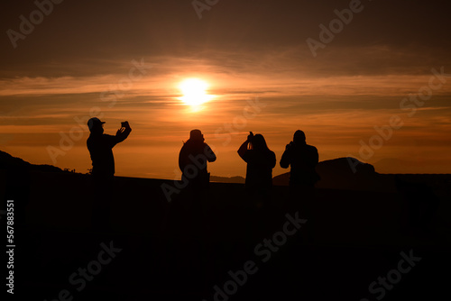A group of young people watching the sun rise from the top of Mount Inthanon