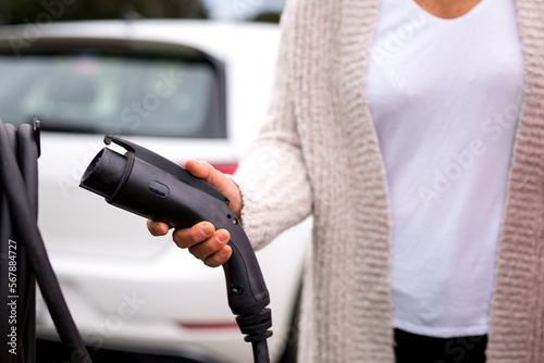 Slika na platnu Une conductrice tient le pistolet de chargement de la borne électrique