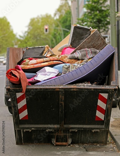 Sperrmüll-Container mit Matratze und alten Möbeln, Verschrottung