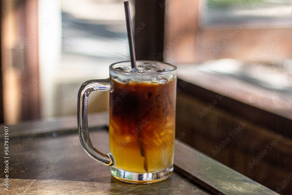 glass of ice americano with honey lemon on wooden table