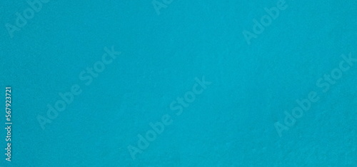 Plastered of cement wall are painted turquoise blue to be used as wallpaper. A vintage-style blank blue wall is perfect for advertising. Empty space on the wall is painted in bright blue. wall texture