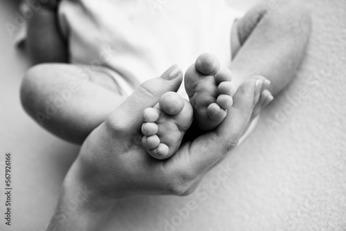 Baby feet in the hands of mother, father, older brother or sister, family. 