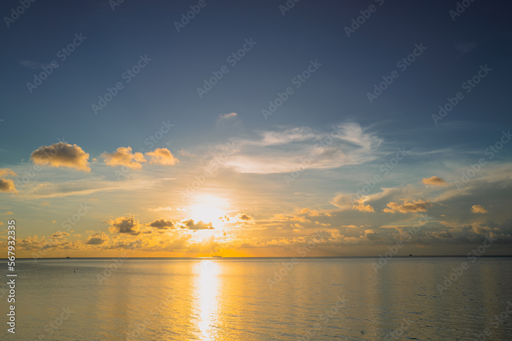 Sunset sea landscape. Colorful beach sunrise with calm waves. Nature sea sky background. Sunrise with clouds of different colors against the blue sky and sea. Vacation travel holiday banner.