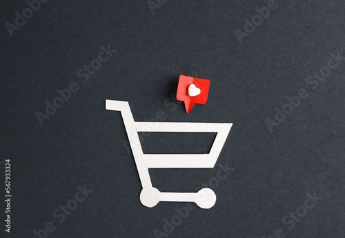 Paper cut shopping trolley with Social media likes on gray background. Creative minimal layout
